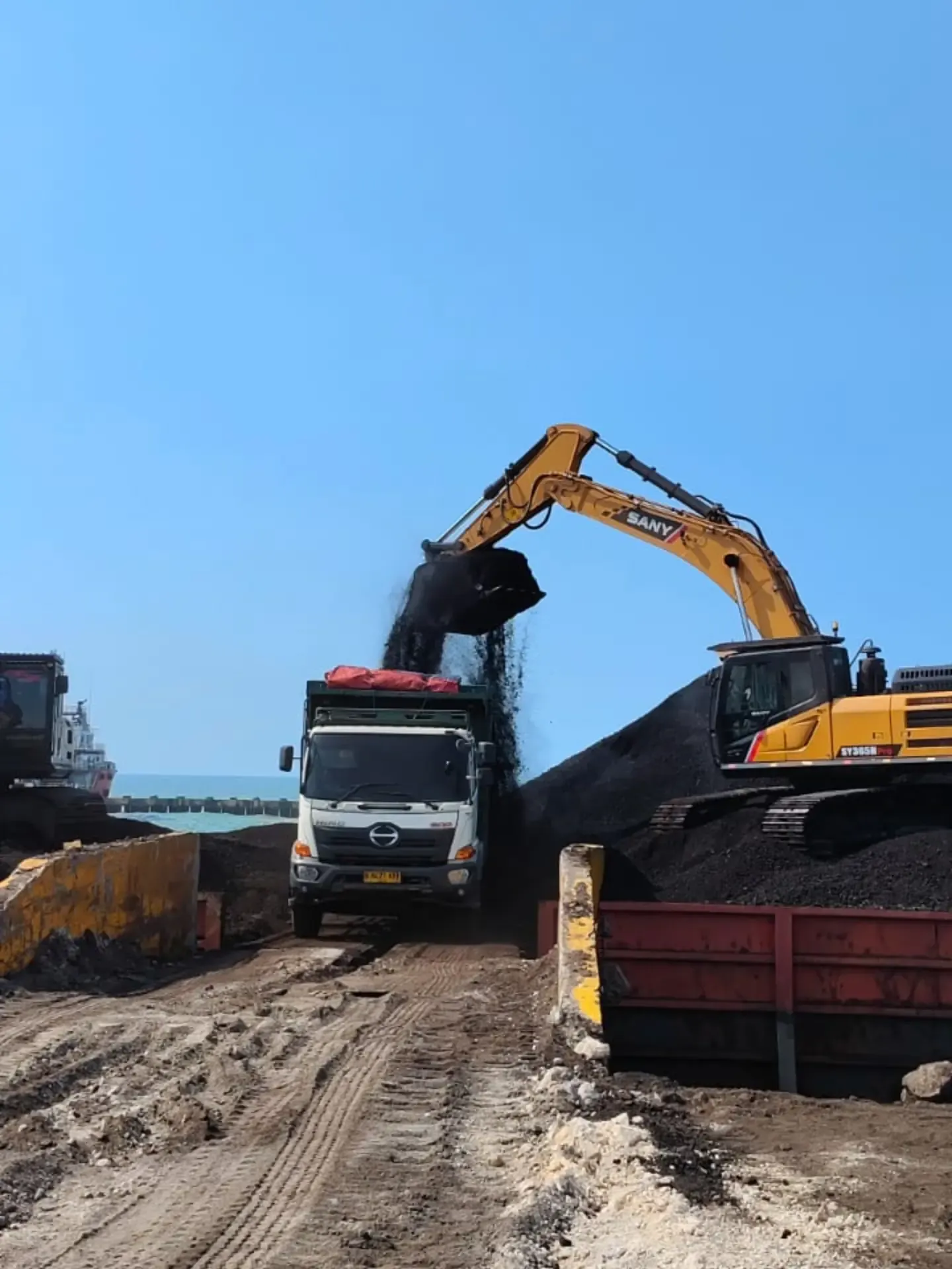 Excavator membongkar batu bara dari tongkang ke dump truck di Jetty Shore Base Lamongan (3/3)