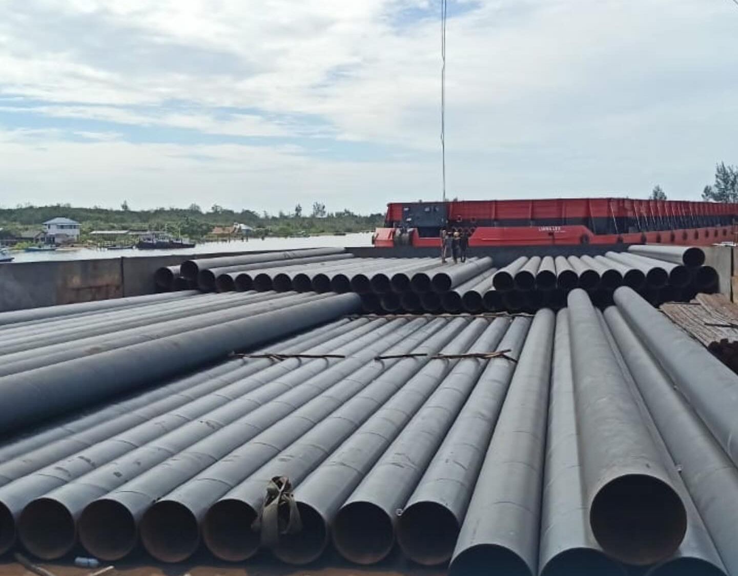 Tiang pancang baja tersusun di dek tongkang 250 feet